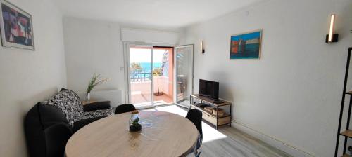 un salon avec une table et un canapé dans l'établissement Nice T2 with terrace by the sea, à Fréjus