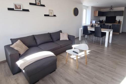 un salon avec un canapé et une table dans l'établissement Appartement À deux pas de tout, à Issoire