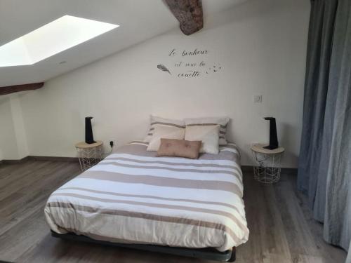 une chambre avec un lit avec un panneau sur le mur dans l'établissement Appartement À deux pas de tout, à Issoire