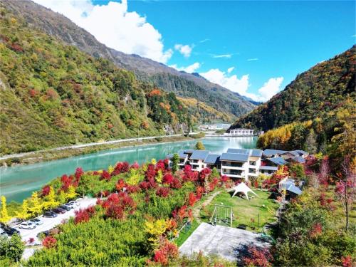 arial view of a resort with a river and mountains at Summergarden Hotel in Wolongguan
