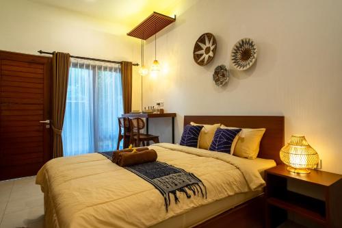 a bedroom with a bed and a table with a chair at Mesari Homestay in Sanur