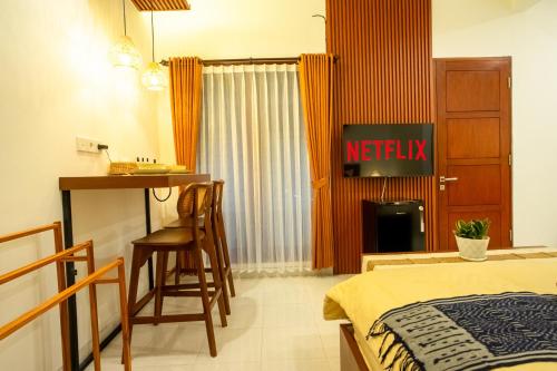 a bedroom with a bed and a table and chairs at Mesari Homestay in Sanur