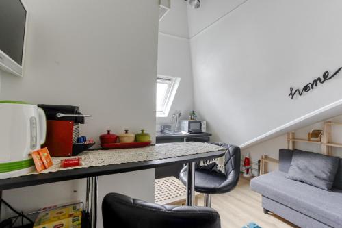 une cuisine avec une table et des chaises dans une pièce dans l'établissement Studio Home Blanc - Au coeur de Vincennes, à Vincennes