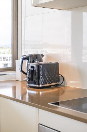 a toaster sitting on top of a kitchen counter at Duporth - Luxury Riverfront Apartment in Maroochydore
