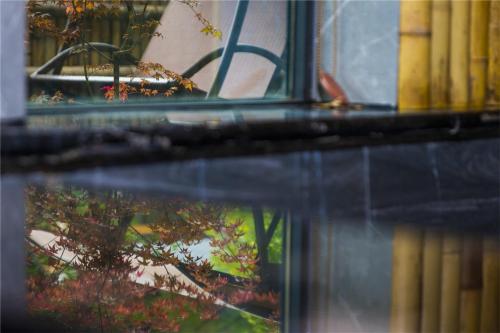 a reflection of a chair in a window at Summergarden Hotel in Wolongguan