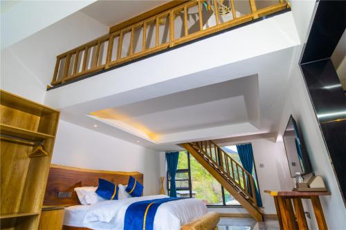 a bedroom with a large bed with blue pillows at Summergarden Hotel in Wolongguan