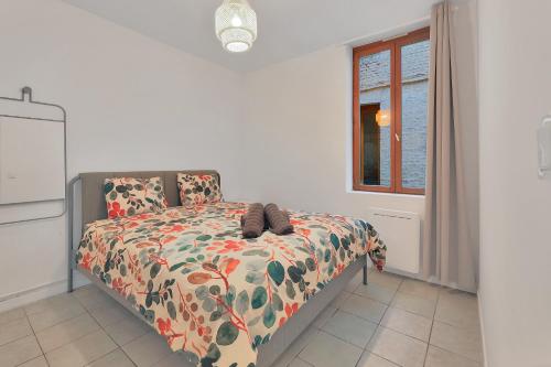une chambre avec un lit avec une couette et une fenêtre dans l'établissement L'Éclat d'Eucalyptus - Appt pour 2 à Saint-Quentin, à Saint-Quentin