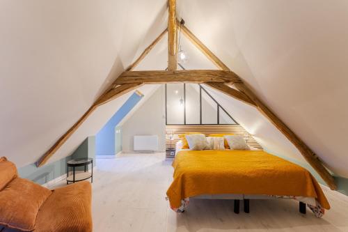 a bedroom with a bed in a attic at Gite de la ferme du château 1 - Appt climatisé in Denezé-sous-Doué