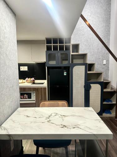 a kitchen with a table and chairs in a room at KunKin Garden Aparthotel in Ho Chi Minh City