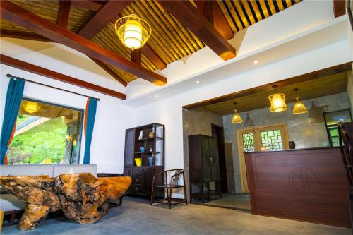 a living room with a couch and a table at Summergarden Hotel in Wolongguan