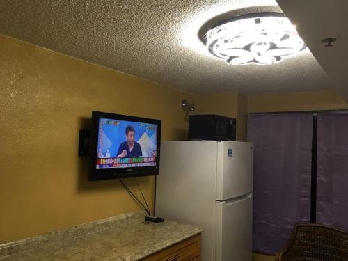 a living room with a tv and a refrigerator at A Cozy Studio at Waikiki in Honolulu