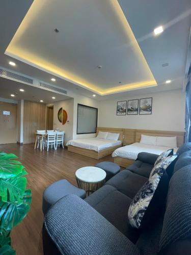 a living room with two beds and a screen at Tony Apartment -FLC Sea Tower Quy Nhon in Quy Nhon