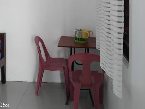 a table and two chairs in a room at Francis Home Stay Port Barton bonifacio street in San Vicente