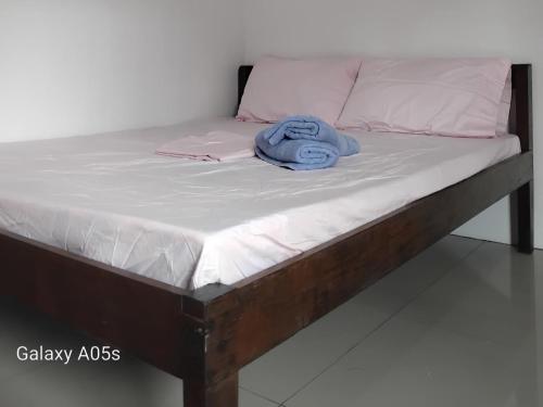 a bed with a blue towel on top of it at Francis Home Stay Port Barton bonifacio street in San Vicente