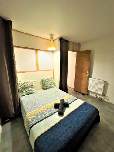 a bedroom with a bed with a black shoe on it at Logement Entier 2 Pièces Avec Grande Terasse Proche Gare in Melun