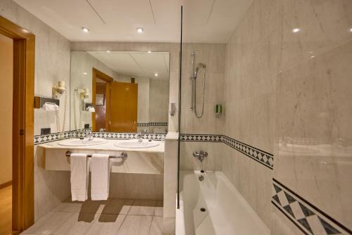 a bathroom with a tub and a sink and a shower at Civis Jaime I in Castellón de la Plana