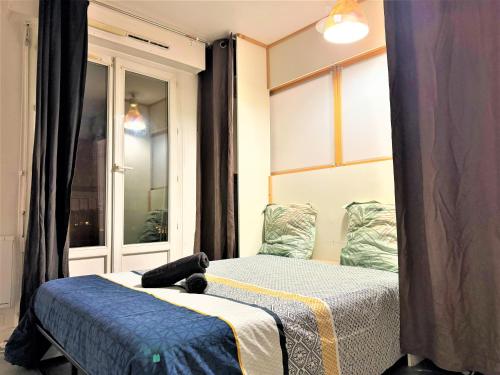 two beds in a room with a window at Logement Entier 2 Pièces Avec Grande Terasse Proche Gare in Melun