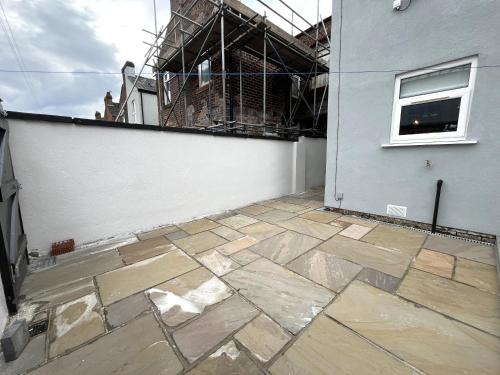 a stone patio outside of a building at Spacious home sleeps 8 Nr Etihad Coop Live & City in Manchester