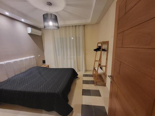 Un dormitorio con una cama y una puerta de madera. en NOUR appartement, en Sidi Daoud