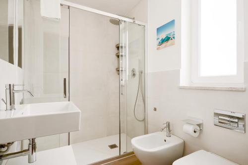 a white bathroom with a sink and a shower at Keys of Sicily - Residence "Sabbia" sul mare in Marina di Modica