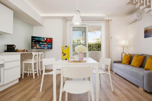 a kitchen and living room with a white table and chairs at Keys of Sicily - Residence "Sabbia" sul mare in Marina di Modica