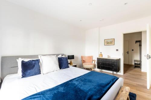 a bedroom with a large bed with blue pillows at City View Spacious 2 bedroom Penthouse in London
