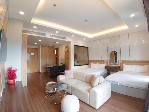 a hotel room with two beds and a couch at Tony Apartment -FLC Sea Tower Quy Nhon in Quy Nhon