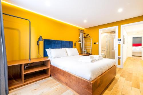 a bedroom with a bed and a yellow wall at Trendy Kings Cross Flat in London