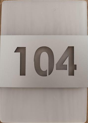 a white clock with the number on it at Sunčana planina apartman 104 in Kopaonik