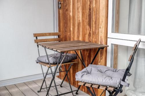 a table and two chairs sitting next to a window at Canning Town Pied-à-Terre in London