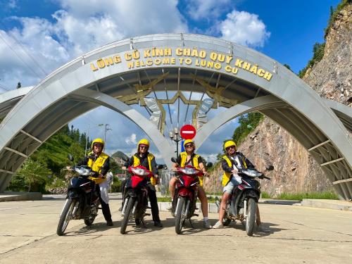 a group of people riding motorcycles under a bridge at Strawberry House , Tour & Motorbikes Rentel in Ha Giang