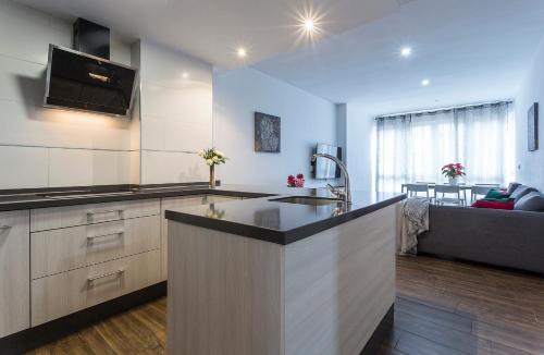 a kitchen with a counter top and a living room at Playa Victoria Paseo Marítimo 3 Rooms in Cádiz