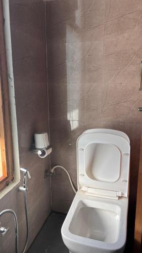a bathroom with a white toilet in a room at Peppy Nomads Luxuria in Jibhi