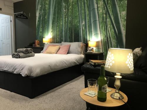 a bedroom with a bed and a table with a lamp at Contemporary 1 bed studio for comfy stay in Wigan in Wigan