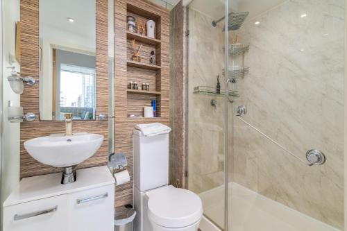 a bathroom with a shower and a toilet and a sink at Canary Wharf Retreat with Free Secure Parking in London