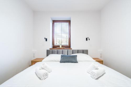 a bedroom with a large white bed with two white towels at Penzion Mountain in Čeladná