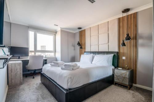 a bedroom with a bed with a desk and a computer at Canary Wharf Retreat with Free Secure Parking in London