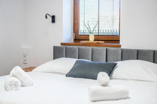 a bedroom with a bed with white sheets and a window at Penzion Mountain in Čeladná