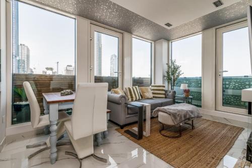 a living room with a couch and a table and windows at Canary Wharf Retreat with Free Secure Parking in London