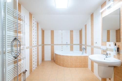 a bathroom with a tub and a sink at Penzion Mountain in Čeladná