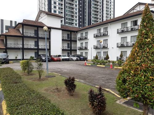 a large building with cars parked in a parking lot at Hotel Seri Malaysia Pulau Pinang in Bayan Lepas