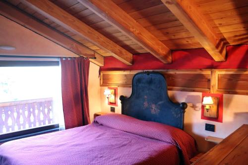 a bed in a room with a red wall at Agriturismo B&B Chèvres à Cheval in Aosta