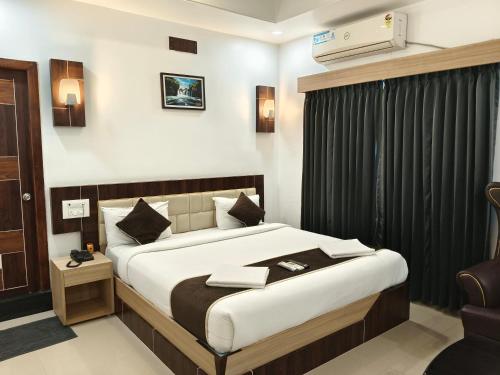a hotel room with a bed and a chair at Hotel M S Pride in Tirupati