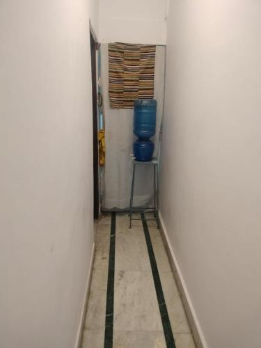 a hallway with a blue bucket sitting on a stool at Beauty Guest House in Bodh Gaya