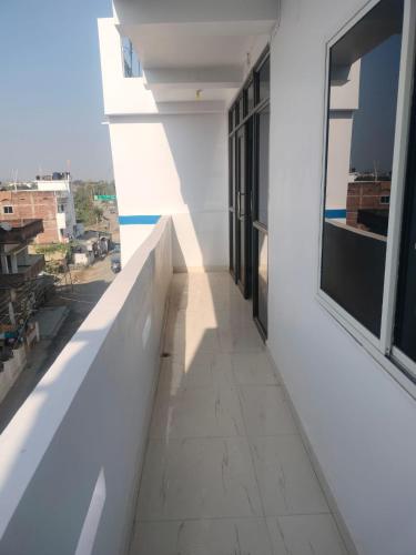 a hallway of a white building with a window at Beauty Guest House in Bodh Gaya