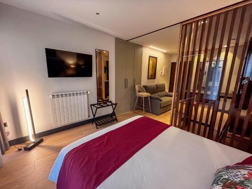 a bedroom with a bed and a tv on the wall at La Quinta del Sordo in Luarca