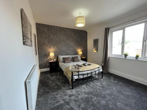 a bedroom with a bed and a large window at Modernised central Wigan townhouse sleeps up to 6 in Wigan