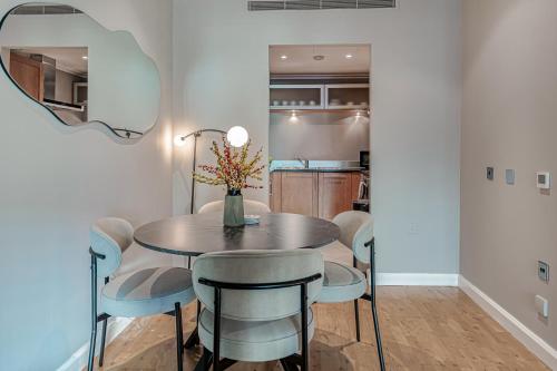 a dining room with a table and chairs and a mirror at MySquare South Quay 02 Bed Water Front Apartments in Canary Wharf in London