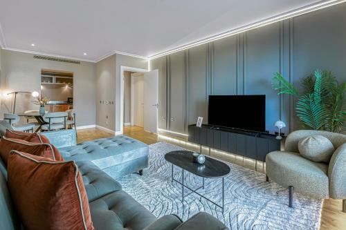 a living room with a couch and a tv at MySquare South Quay 02 Bed Water Front Apartments in Canary Wharf in London