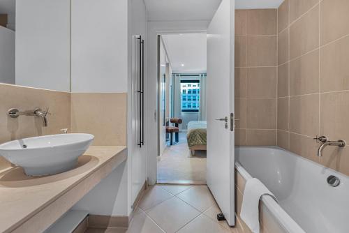 a bathroom with a white tub and a sink at MySquare South Quay 02 Bed Water Front Apartments in Canary Wharf in London
